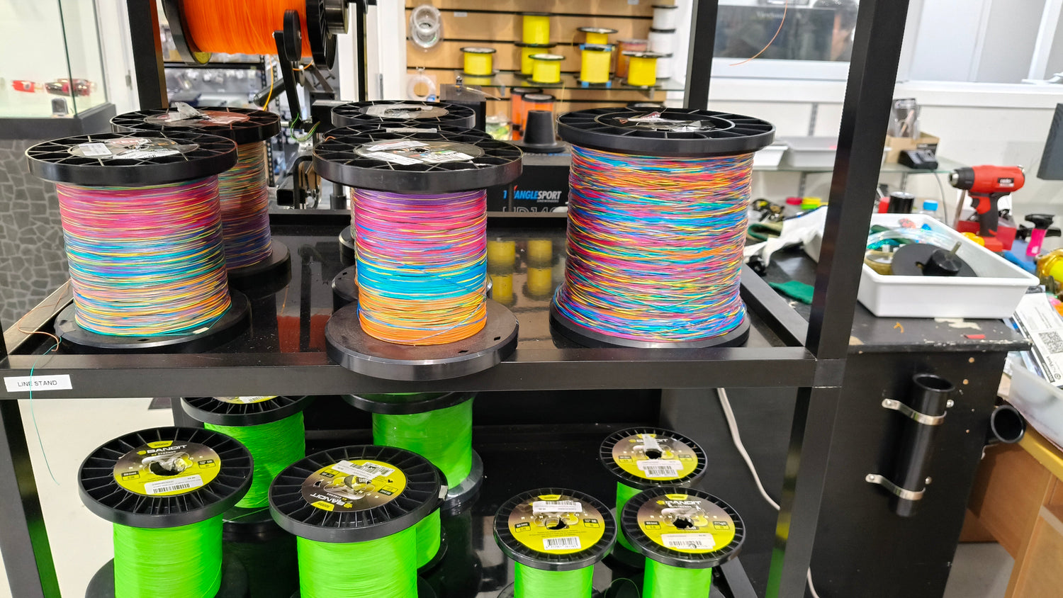 Braided lines, hollow core on fishing spools in orange, blue, and teal.