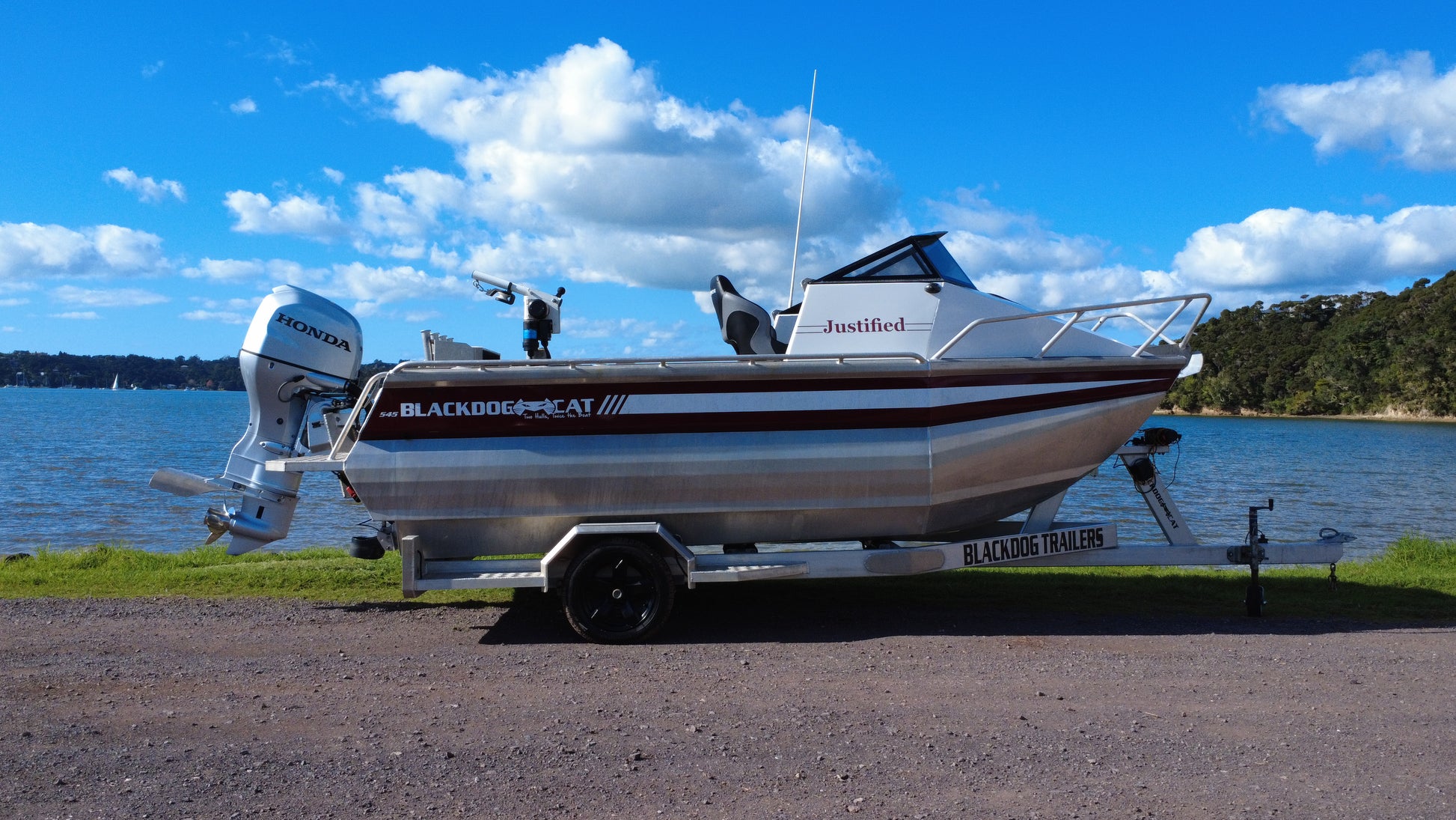 Side view of used Black Dog Cat 545 aluminium power catamaran on trailer