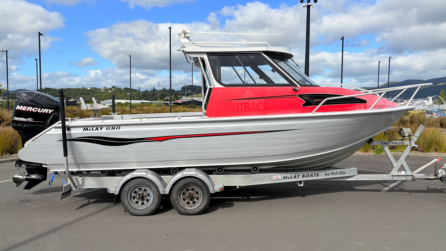Used 2010 McLay 680 hardtop boat powered by a 225hp Mercury Optimax outboard, sitting on a tandem-axle Toko trailer. Features include boarding ladder, bait board, trim tabs, step mounts, livebait tank, twin batteries with VSR and isolation switch, GME VHF, Lowrance HDS 8, and 170L underfloor fuel tank. Warren Hay Marine, Whangarei