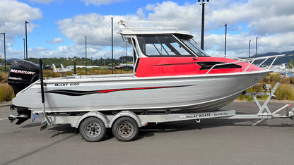 Used 2010 McLay 680 hardtop boat powered by a 225hp Mercury Optimax outboard, sitting on a tandem-axle Toko trailer. Features include boarding ladder, bait board, trim tabs, step mounts, livebait tank, twin batteries with VSR and isolation switch, GME VHF, Lowrance HDS 8, and 170L underfloor fuel tank. Warren Hay Marine, Whangarei