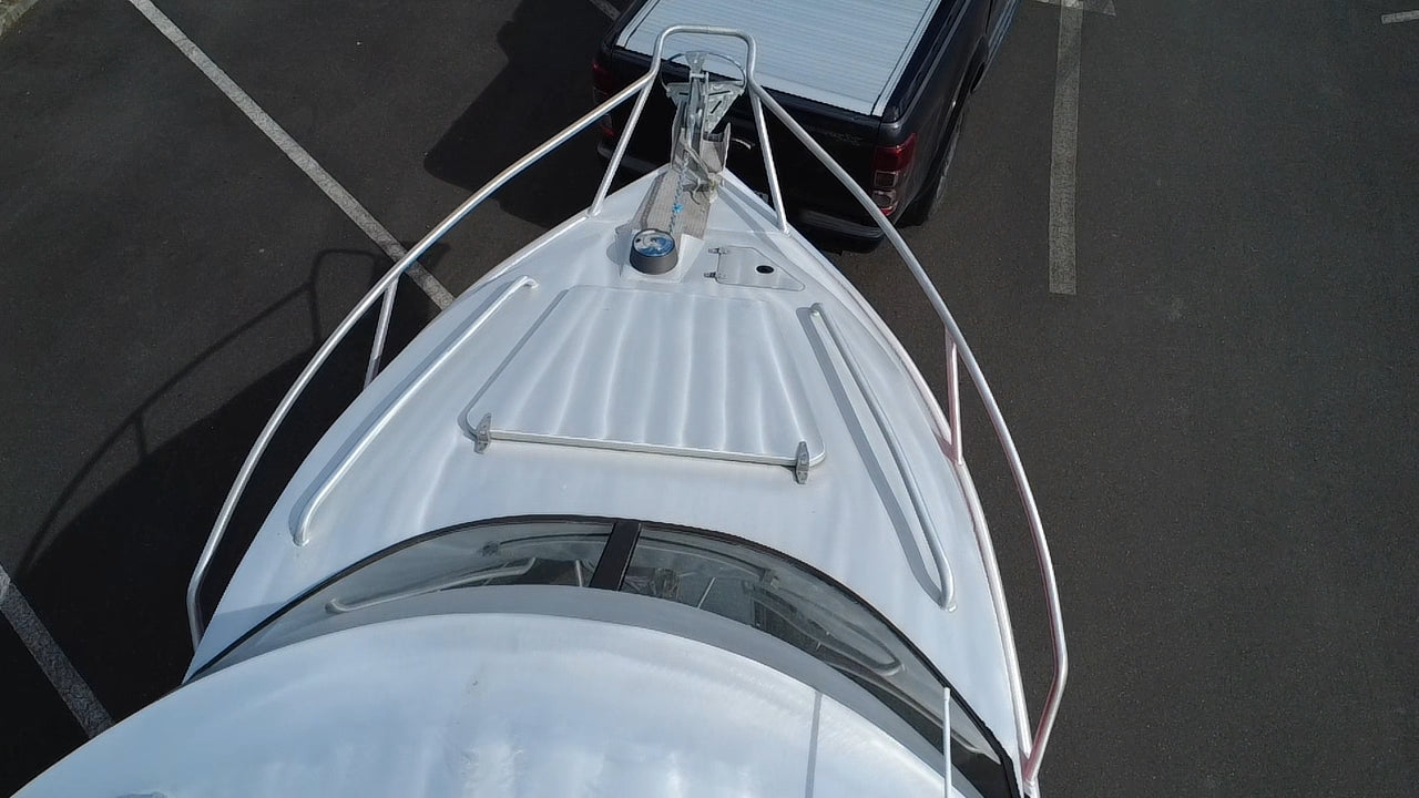 Used 2010 McLay 680 hardtop boat powered by a 225hp Mercury Optimax outboard, sitting on a tandem-axle Toko trailer. Features include boarding ladder, bait board, trim tabs, step mounts, livebait tank, twin batteries with VSR and isolation switch, GME VHF, Lowrance HDS 8, and 170L underfloor fuel tank. Warren Hay Marine, Whangarei