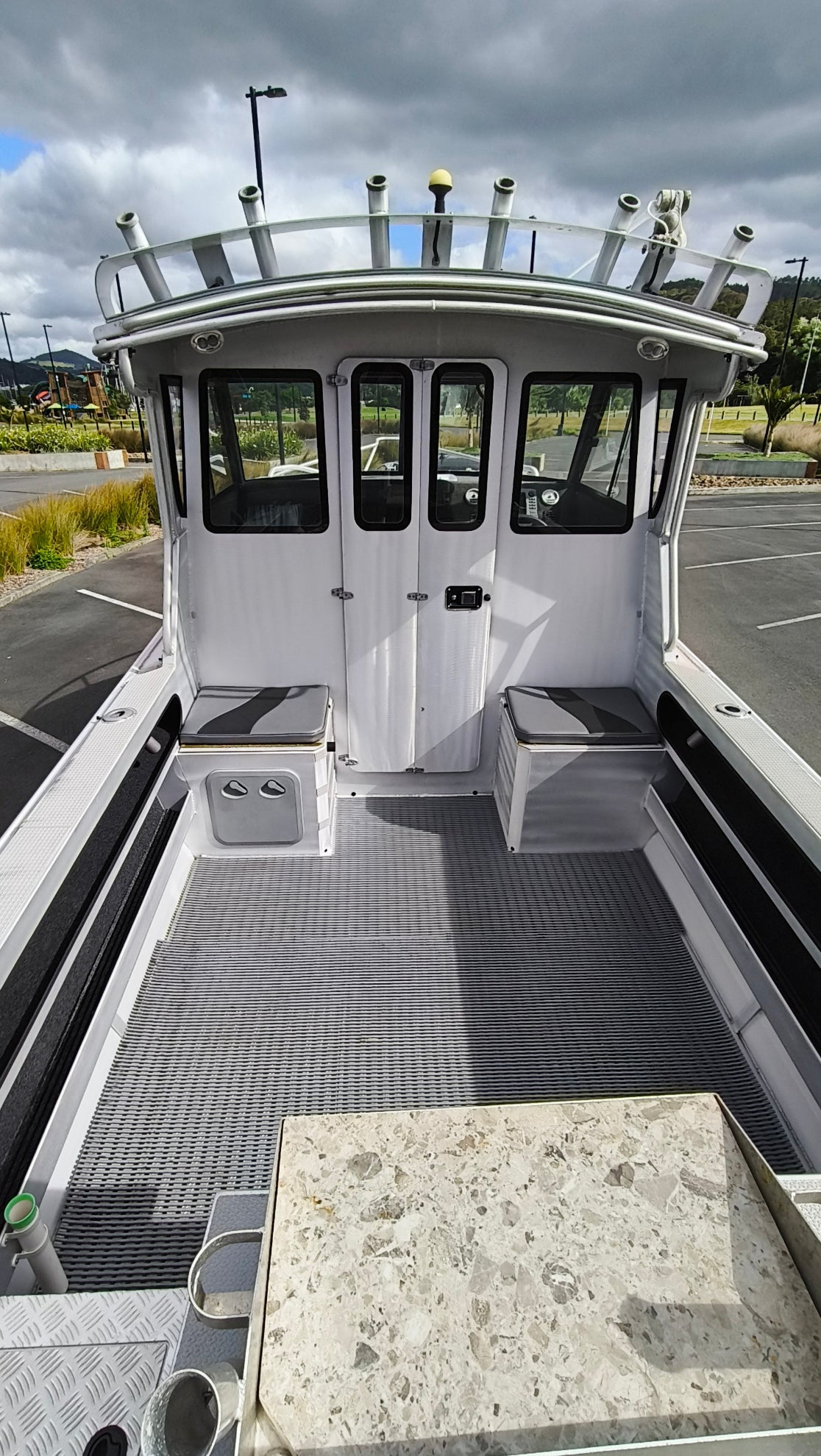 Used 2010 McLay 680 hardtop boat powered by a 225hp Mercury Optimax outboard, sitting on a tandem-axle Toko trailer. Features include boarding ladder, bait board, trim tabs, step mounts, livebait tank, twin batteries with VSR and isolation switch, GME VHF, Lowrance HDS 8, and 170L underfloor fuel tank. Warren Hay Marine, Whangarei