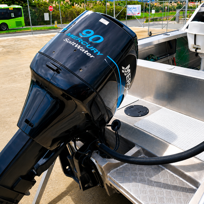 Used Boats, Close-up of the Mercury 90hp Saltwater two-stroke outboard fitted to a used Ramco Getaway, showing the transom, rear deck, and cockpit layout. Warren Hay Marine
