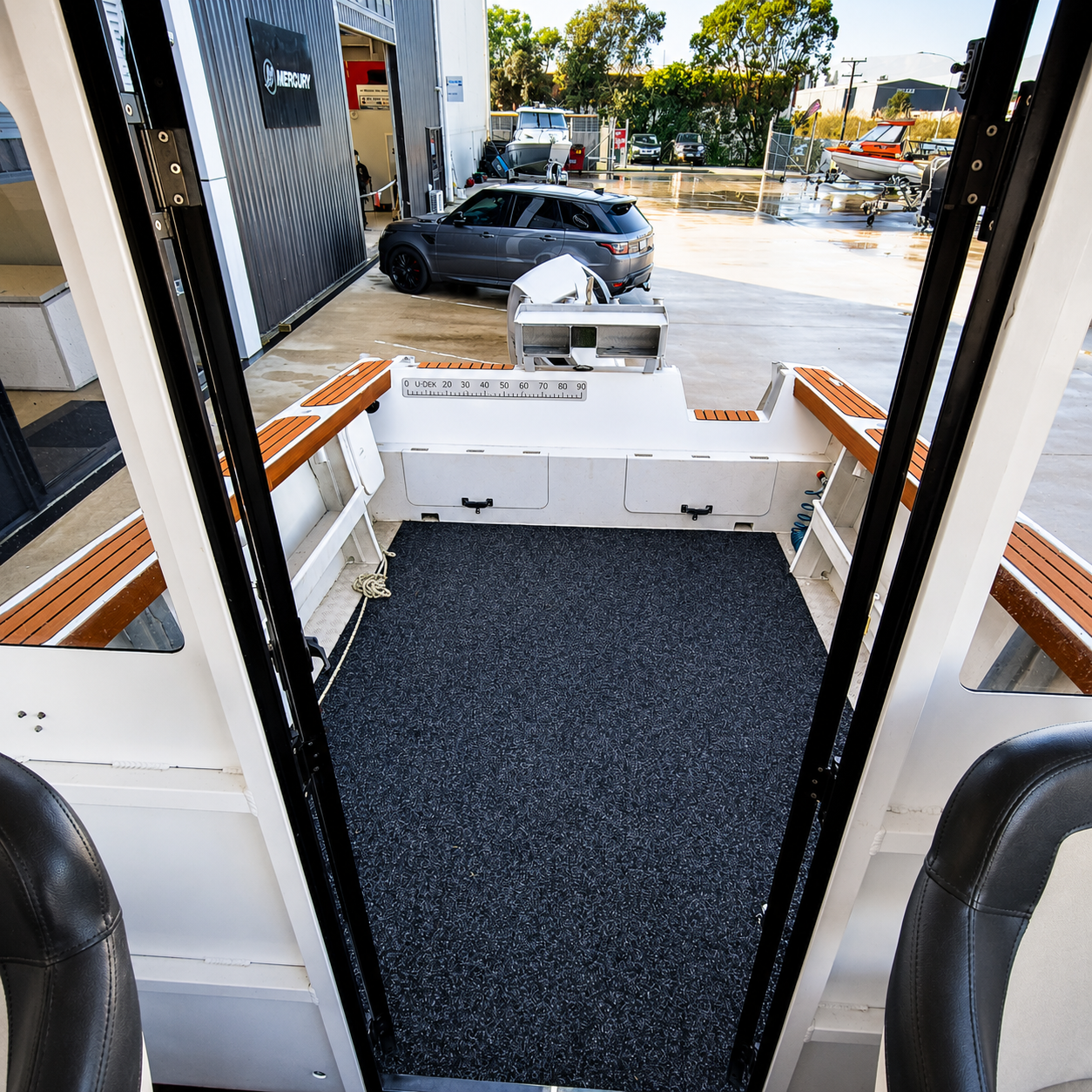 View from the cabin of the used Brave HT 800 hardtop looking into the spacious self-draining fishing cockpit, featuring wide side shelves, bait station, and open working deck.