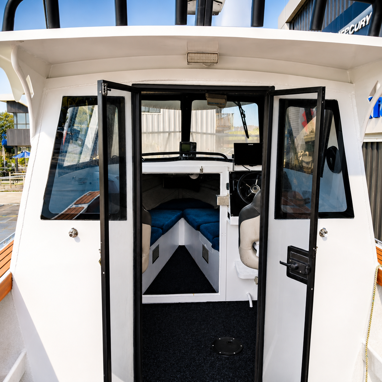 Interior view of the used Brave HT 800 aluminium hardtop boat, showing the spacious V-berth cabin, helm station, sliding cabin doors, and sheltered wheelhouse.
