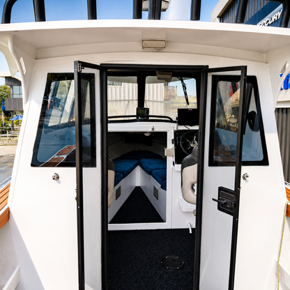 Interior view of the used Brave HT 800 aluminium hardtop boat, showing the spacious V-berth cabin, helm station, sliding cabin doors, and sheltered wheelhouse.