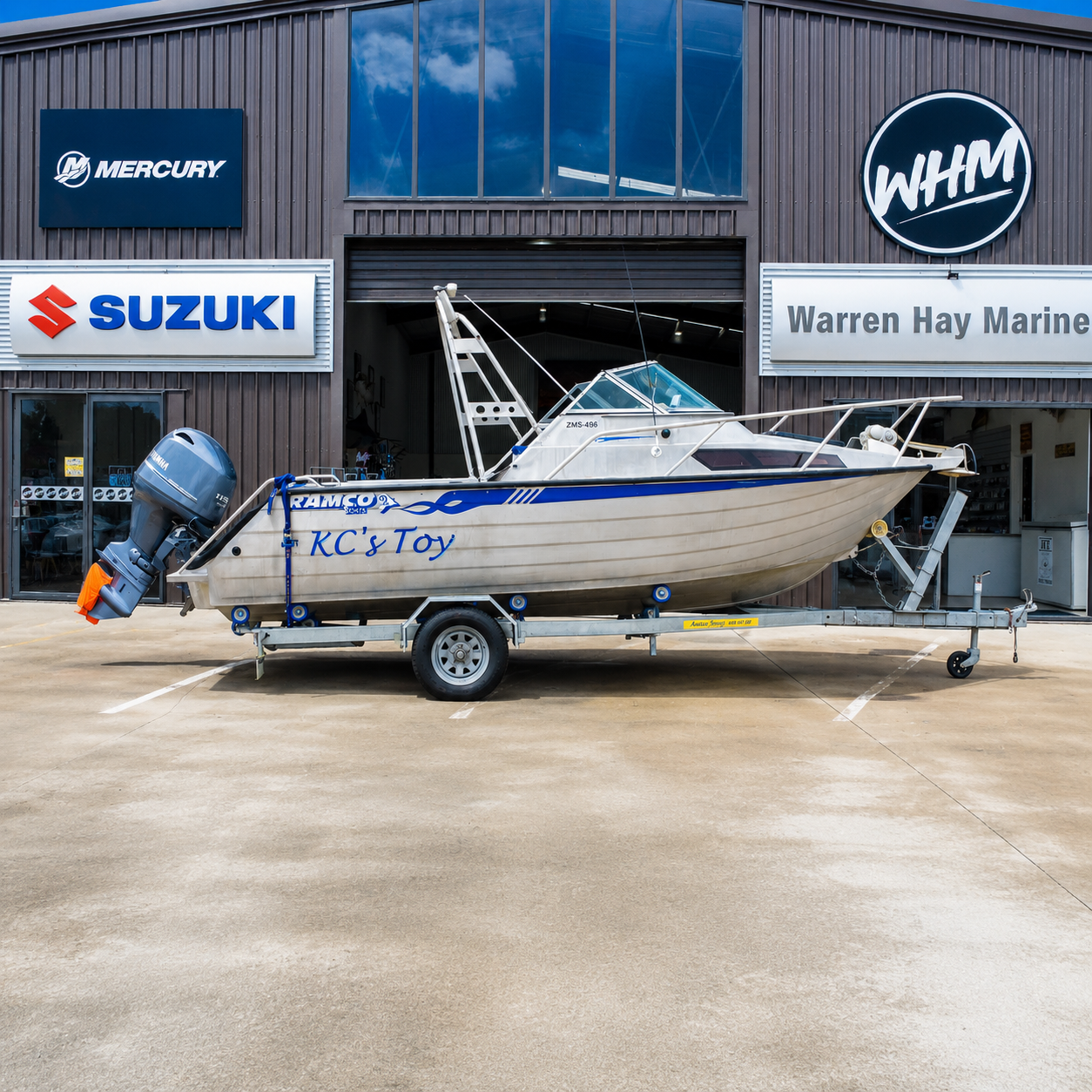 Used Ramco Fishmaster 580 aluminium fishing boat with Yamaha F115 FourStroke outboard on galvanised trailer outside Warren Hay Marine, Whangārei.