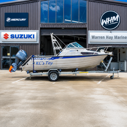 Used Ramco Fishmaster 580 aluminium fishing boat with Yamaha F115 FourStroke outboard on galvanised trailer outside Warren Hay Marine, Whangārei.