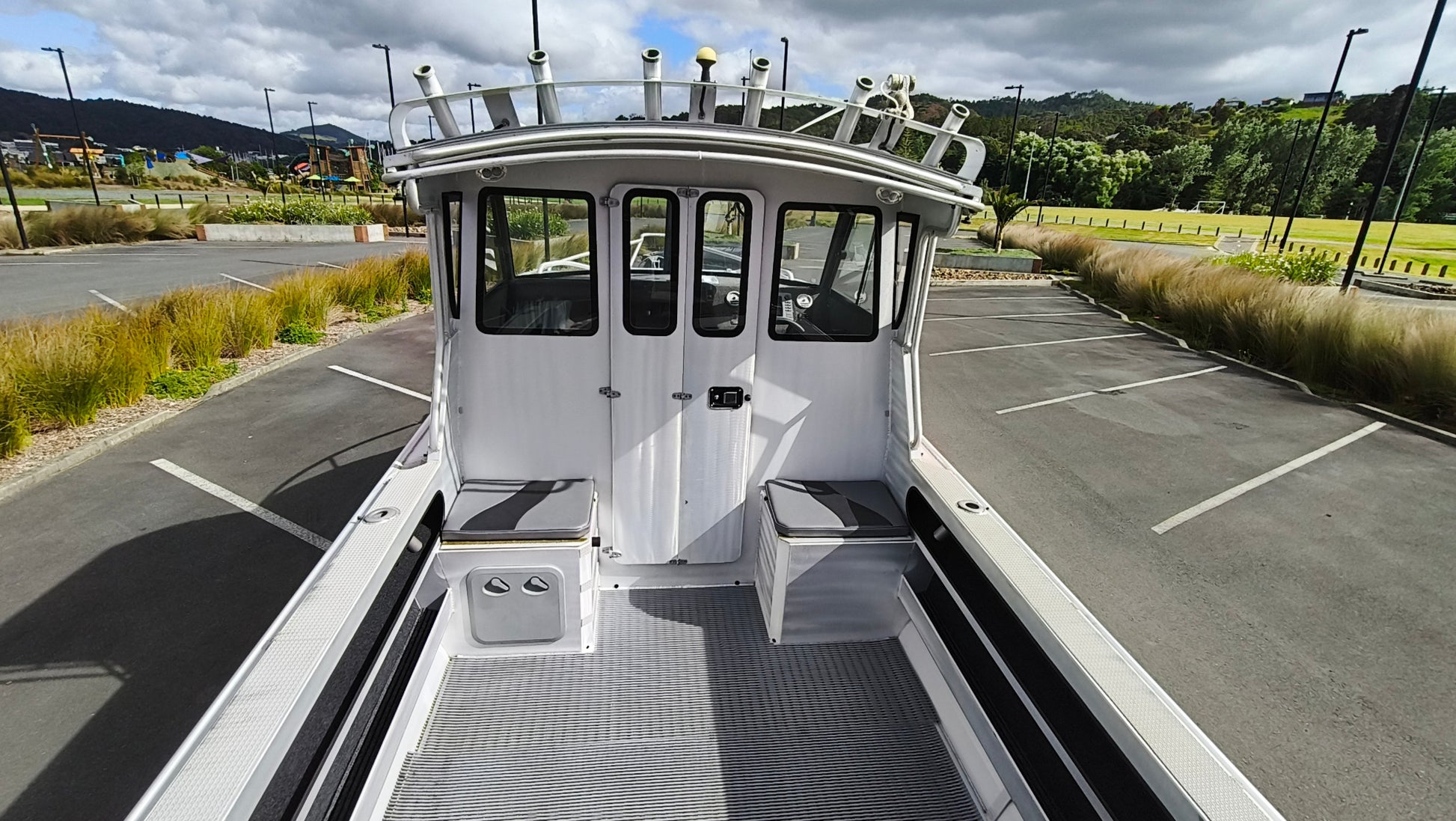 Used 2010 McLay 680 hardtop boat powered by a 225hp Mercury Optimax outboard, sitting on a tandem-axle Toko trailer. Features include boarding ladder, bait board, trim tabs, step mounts, livebait tank, twin batteries with VSR and isolation switch, GME VHF, Lowrance HDS 8, and 170L underfloor fuel tank. Warren Hay Marine, Whangarei