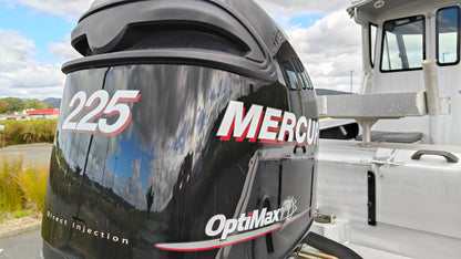 Used 2010 McLay 680 hardtop boat powered by a 225hp Mercury Optimax outboard, sitting on a tandem-axle Toko trailer. Features include boarding ladder, bait board, trim tabs, step mounts, livebait tank, twin batteries with VSR and isolation switch, GME VHF, Lowrance HDS 8, and 170L underfloor fuel tank. Warren Hay Marine, Whangarei