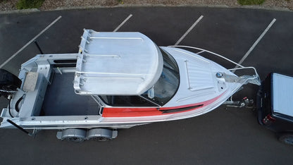 Used 2010 McLay 680 hardtop boat powered by a 225hp Mercury Optimax outboard, sitting on a tandem-axle Toko trailer. Features include boarding ladder, bait board, trim tabs, step mounts, livebait tank, twin batteries with VSR and isolation switch, GME VHF, Lowrance HDS 8, and 170L underfloor fuel tank. Warren Hay Marine, Whangarei