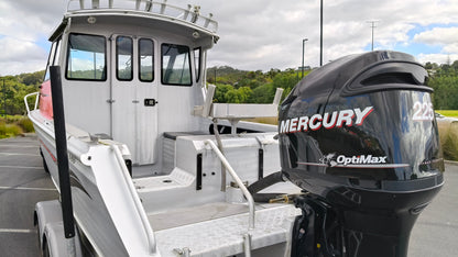 Used 2010 McLay 680 hardtop boat powered by a 225hp Mercury Optimax outboard, sitting on a tandem-axle Toko trailer. Features include boarding ladder, bait board, trim tabs, step mounts, livebait tank, twin batteries with VSR and isolation switch, GME VHF, Lowrance HDS 8, and 170L underfloor fuel tank. Warren Hay Marine, Whangarei