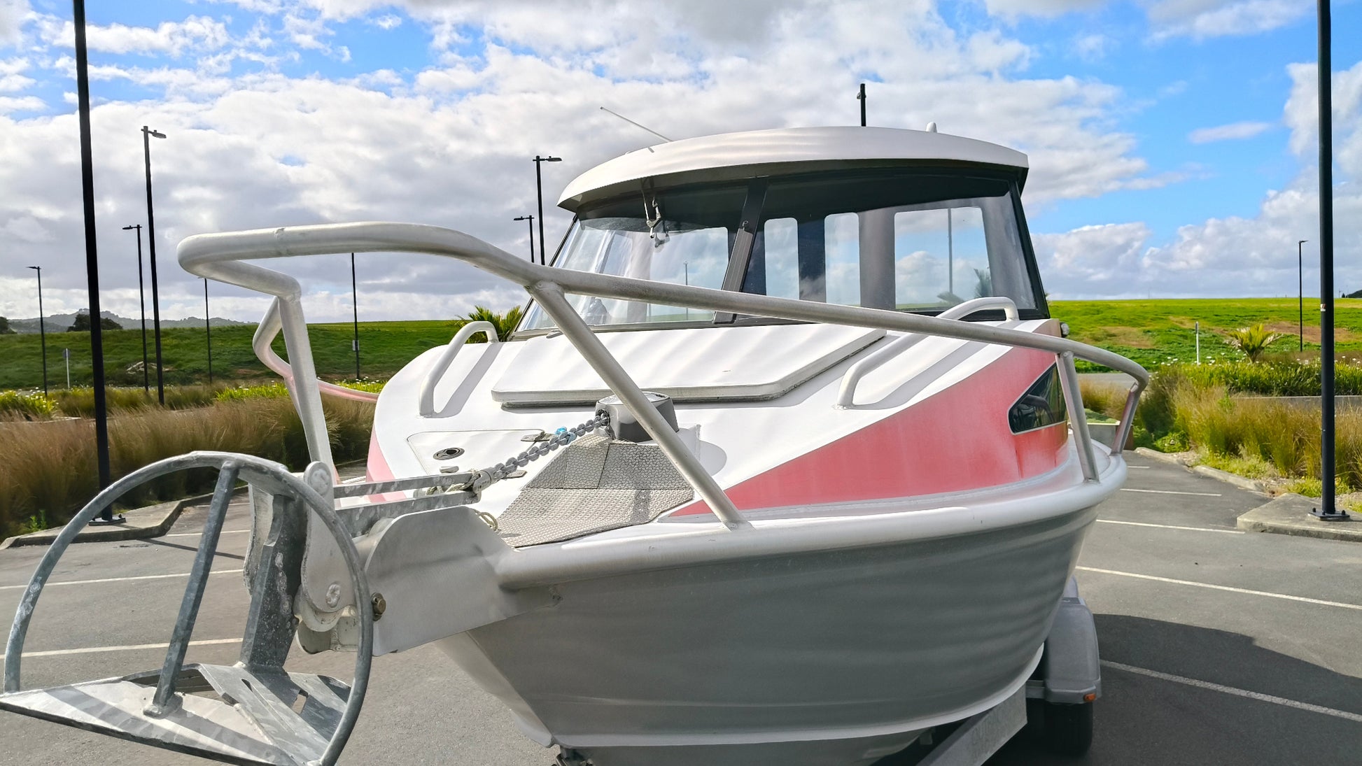 Used 2010 McLay 680 hardtop boat powered by a 225hp Mercury Optimax outboard, sitting on a tandem-axle Toko trailer. Features include boarding ladder, bait board, trim tabs, step mounts, livebait tank, twin batteries with VSR and isolation switch, GME VHF, Lowrance HDS 8, and 170L underfloor fuel tank. Warren Hay Marine, Whangarei