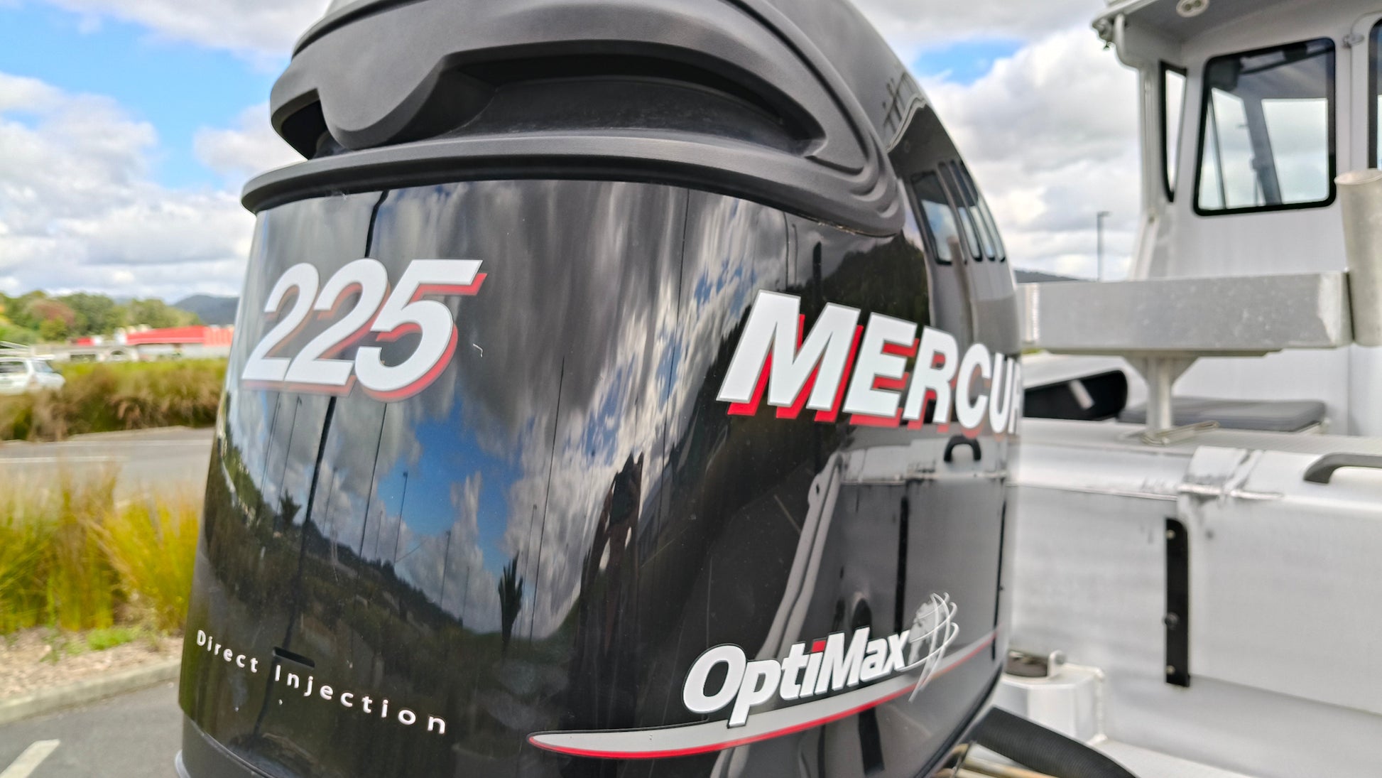 Used 2010 McLay 680 hardtop boat powered by a 225hp Mercury Optimax outboard, sitting on a tandem-axle Toko trailer. Features include boarding ladder, bait board, trim tabs, step mounts, livebait tank, twin batteries with VSR and isolation switch, GME VHF, Lowrance HDS 8, and 170L underfloor fuel tank. Warren Hay Marine, Whangarei