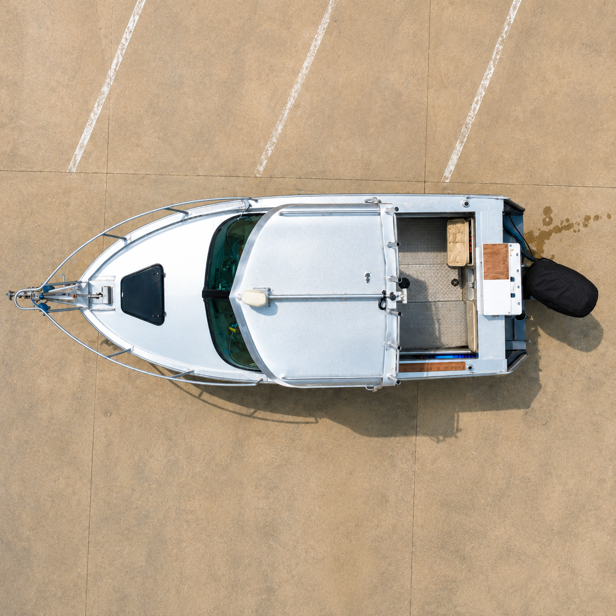 
Top-down aerial view of a 2018 Marco 600 Sou'Wester Hard Top with Suzuki BF140 four-stroke outboard on an Ultra Trailers tandem axle trailer, highlighting the hardtop, open cockpit, bow hatch, and overall deck layout, Warren Hay Marine
