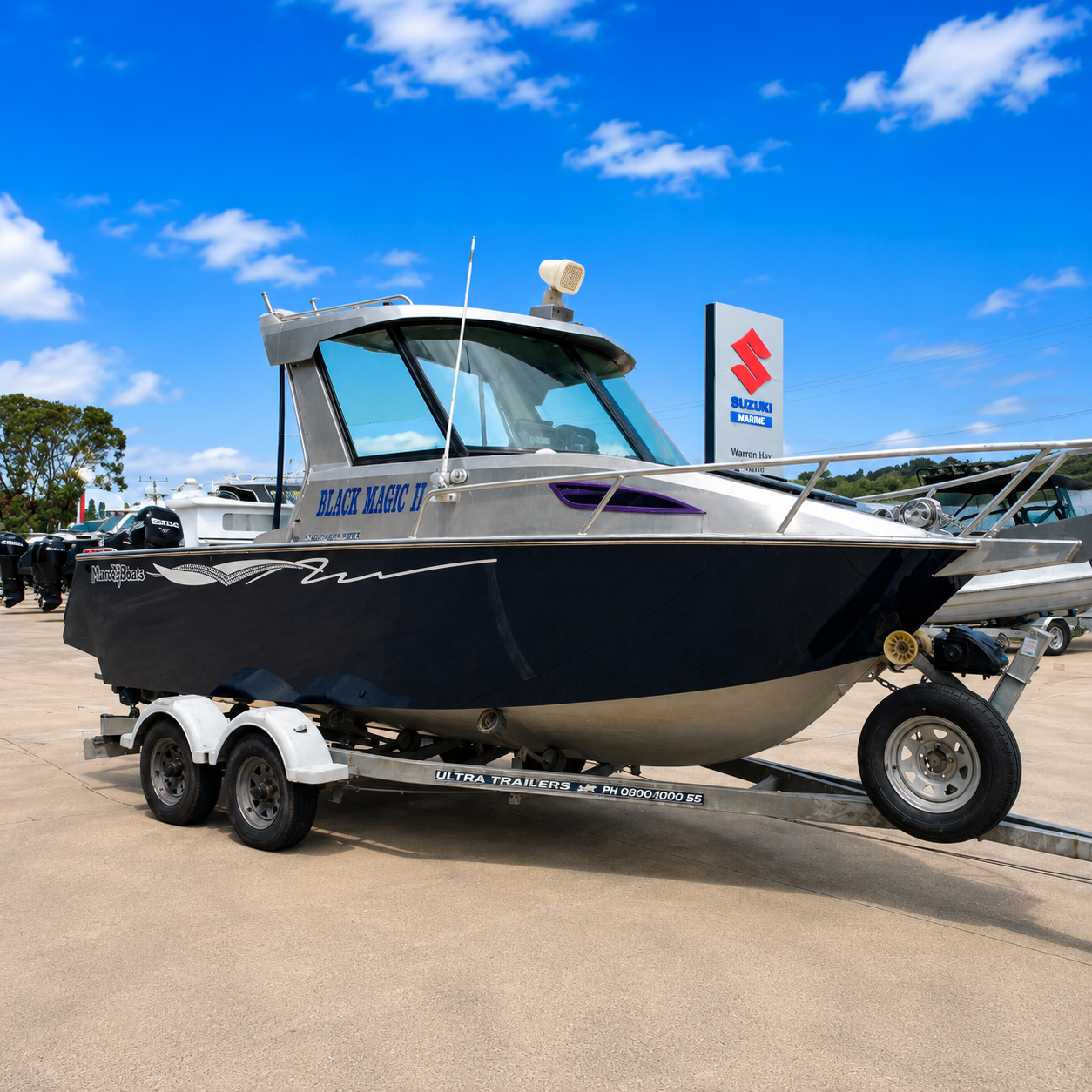 Low-angle front starboard view of a 2018 Marco 600 Sou'Wester Hard Top with Suzuki BF140 four-stroke outboard on an Ultra Trailers tandem axle trailer at Warren Hay Marine, Whangārei.