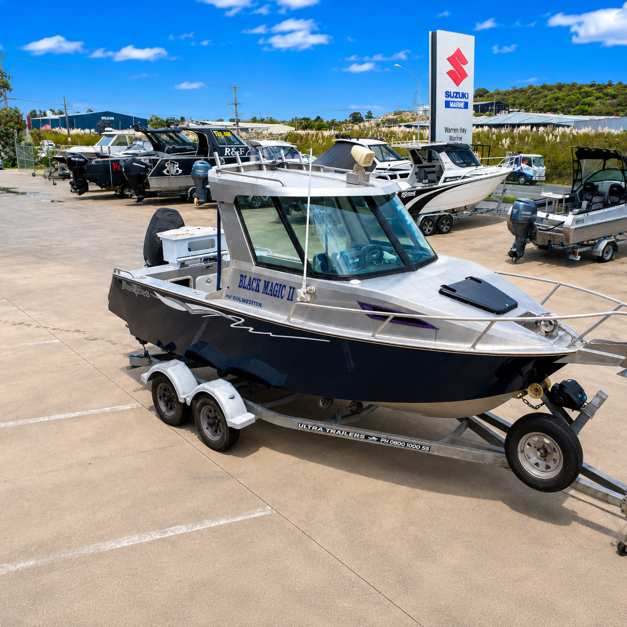High-angle front starboard view of a 2018 Marco 600 Sou'Wester Hard Top with Suzuki BF140 four-stroke outboard on an Ultra Trailers tandem axle trailer at Warren Hay Marine, Whangārei.